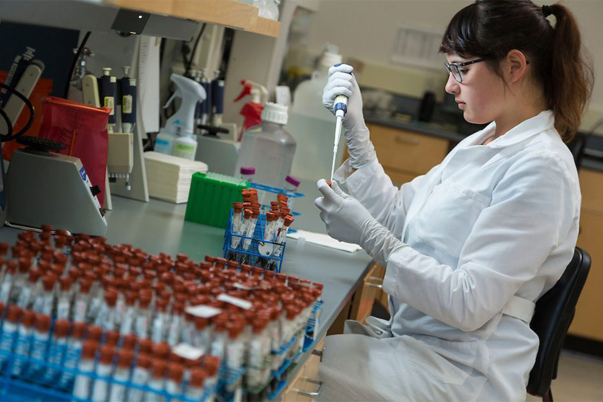 Scientist pipetting samples in an independent supplement-testing laboratory